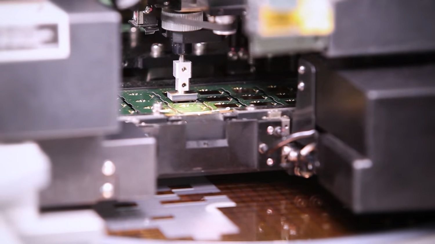 Una máquina toma un chip del alimentador y lo coloca sobre el PCB